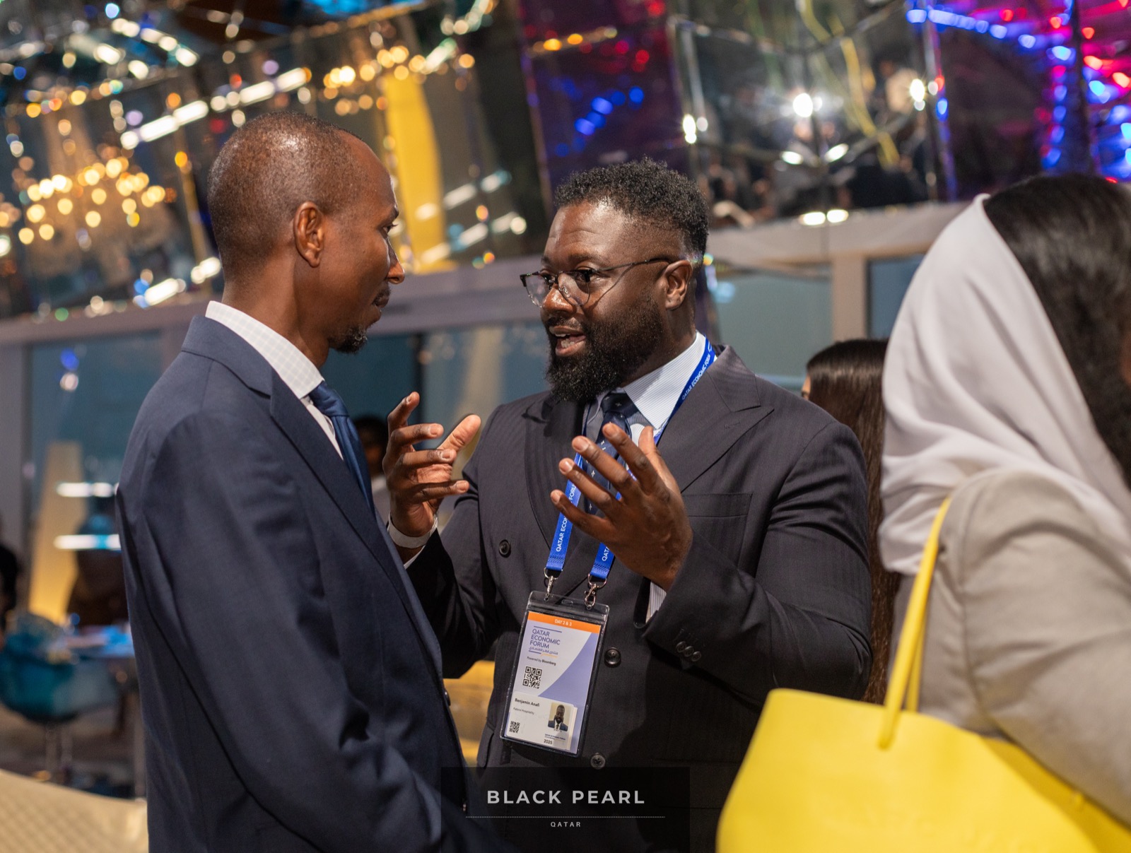 Two members in animated business conversation at a Black Pearl evening