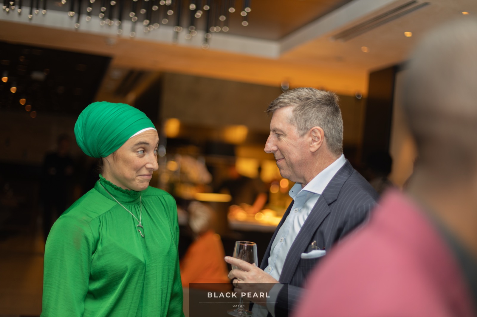 Two guests in warm conversation at a Black Pearl evening